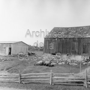 Vieille maison-hangar avec un solage en pierre des champs