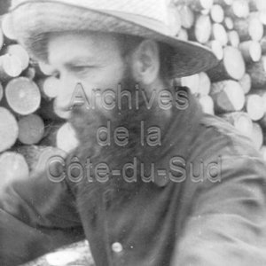 Gros plan sur Ulric Barbe &eacute;cor&ccedil;ant des billots de bois pr&egrave;s de Barraute en Abitibi